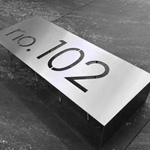 Rectangular metal plate with the number 102 cut through it